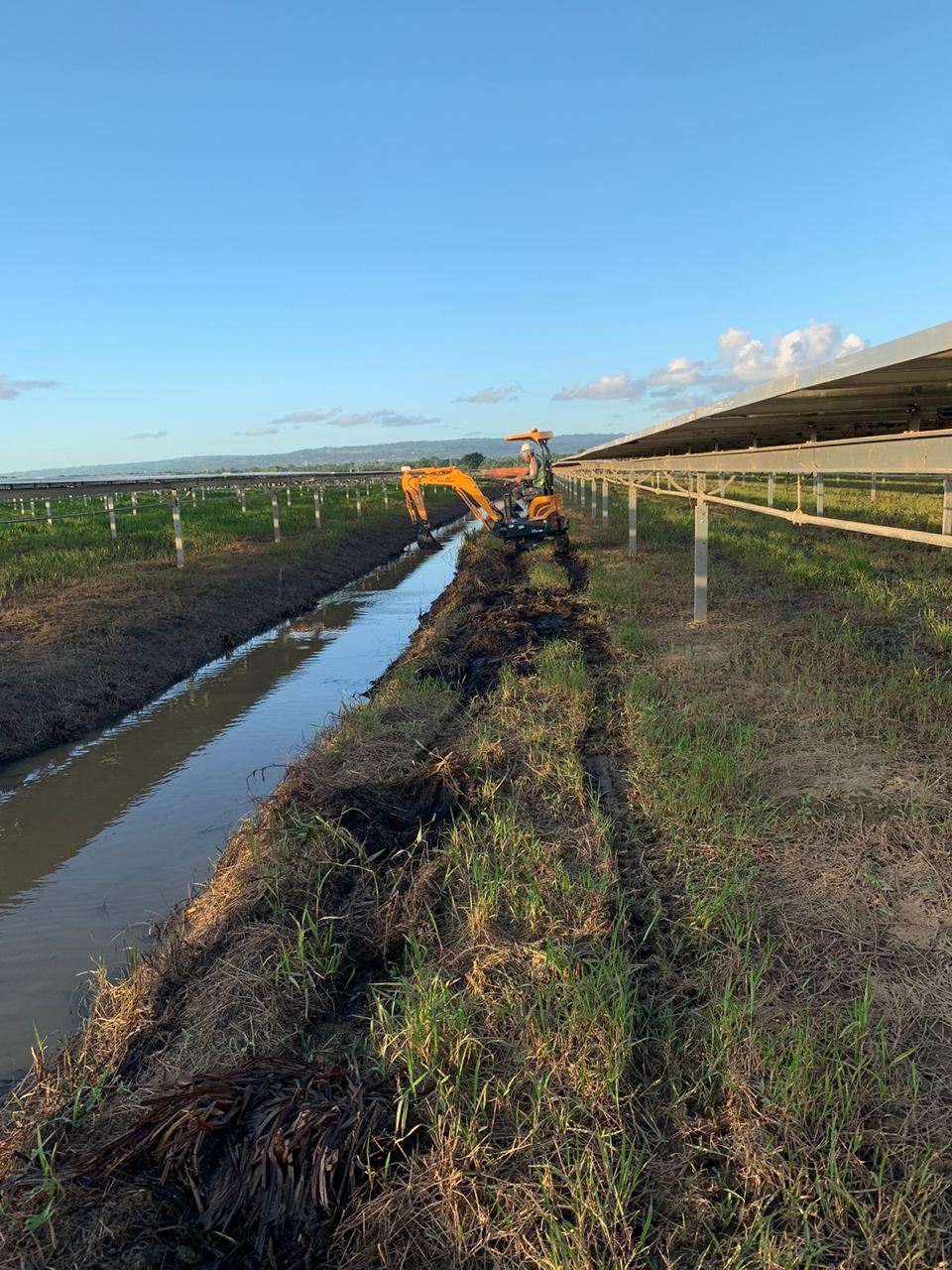 Miniexcavadora limpiando un canal de drenaje