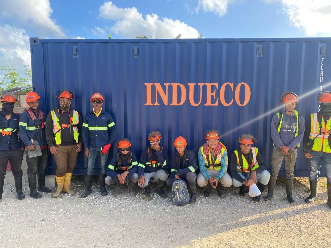 Equipo de INDUECO con su equipo de protección delante del contenedor de la empresa